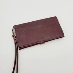 This is a vintage women's credit card wallet made by Duluth Trading Co. It is made of full leather in a solid brown color and features a snap closure. The wallet has a canvas fabric lining and includes a zipper and logo accents. It is designed to hold credit cards and has a money theme. The wallet is not handmade and was manufactured in China. Vintage Brown Rectangular Wallets For Daily Use, Vintage Brown Wallet For Travel, Rectangular Vintage Brown Wallet For Daily Use, Vintage Brown Travel Wallet, Vintage Brown Bifold Wallet For Daily Use, Vintage Brown Wallets For Daily Use, Vintage Brown Wallets With Card Slots For Daily Use, Vintage Brown Wallet With Card Slots For Daily Use, Distressed Brown Rectangular Wallet For Everyday Use