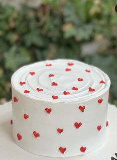 a white cake with red hearts on it