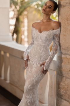 a woman in a wedding dress leaning against a wall