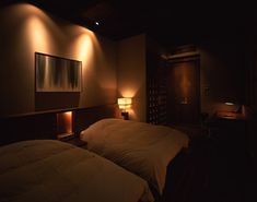 two beds in a dimly lit room with lamps