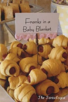 there is a plate full of pigs in a blanket on display at the baby shower