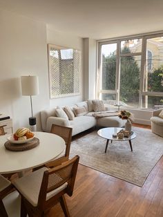 a living room filled with furniture next to a large window covered in lots of windows