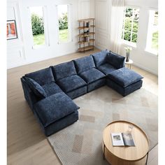 a large blue sectional sofa sitting on top of a living room floor next to a coffee table