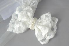 a white lace bow with pearls on it