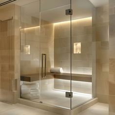 a bathroom with a glass shower door and tiled walls