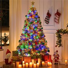 a lit christmas tree surrounded by presents and candles