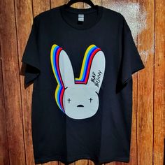 Bad Bunny Shirt Conejo Malo Shirt. New Without Tags Size Large Length: 31in" Armpit To Armpit:22in" If You Have Any Questions Or Concerns Please Feel Free To Contact Us We Are Always Happy To Help. Have A Blessed Day Multicolor Band Merch Top With Graphic Design, Multicolor Graphic Design Top Band Merch, Multicolor Front Print Top For Streetwear, Multicolor Crew Neck Band Merch Tops, Multicolor Cotton Band Merch Tops, Multicolor Crew Neck Shirt For Streetwear, Casual Multicolor Shirt With Front Print, Always Happy, Bunny Shirt