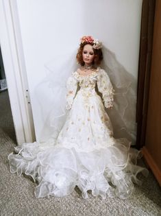 a doll is dressed in a white dress