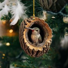 an ornament shaped like a bird in a nest hanging from a christmas tree