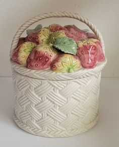 a white basket filled with fruit sitting on top of a table