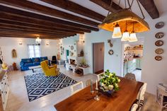 a dining room table and some chairs in a room with wood beams on the ceiling