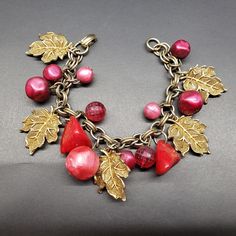 "DESCRIPTION:  -Beautiful Vintage Charm Bracelet - Great condition - Raspberry and reddish colored beads.  7 1/4\" -   Gold-tone Leaves and Chain - Exciting to wear and great to Collect From the 30s, 40s -  Lucite/plastic - Fancy -  Very Attractive      WELCOME to \"SHOPDELIALARA\". I am glad you are visiting my Etsy Shop. I have collected vintage jewelry since I was in my 20s - buying in garage sales, thrift stores and estate sales. Collecting was fun. I am 86 and now I am more interested in se Red Metal Costume Jewelry Bracelets, Red Metal Costume Jewelry Bracelet, In My 20s, Leaves Vintage, Group Picture, Vintage Charm Bracelet, Gold Leaves, Group Photo, Thrift Stores