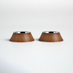 two brown lampshades sitting next to each other on a white surface