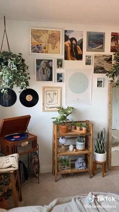 a living room filled with lots of plants and pictures on the wall above it is a record player