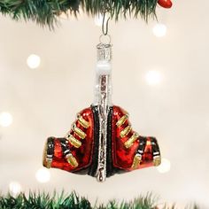 an ornament hanging from a christmas tree with red and gold shoes on it