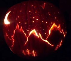 a carved pumpkin with mountains and stars on it