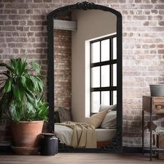 a mirror sitting on top of a wooden floor next to a potted plant