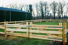 a wooden fence in the middle of a field