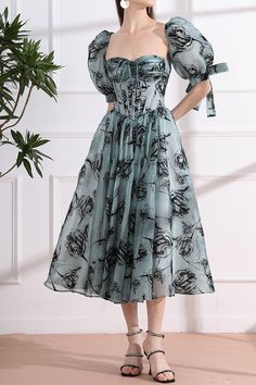 Unleash your inner elegance with our Corset Floral Print Organza Midi Dress. Featuring a delicate organza fabric adorned with a beautiful floral print, this dress exudes luxury. Add a touch of drama by attaching the removable puff sleeves, perfect for any special occasion. Elevate your style with this sophisticated and exclusive piece. Bust and Skirt with full lining. 100% Polyester 100% Recycled polyester lining Concealed zip at center back Imported Elegant Spring Chiffon Dress For Banquet, Feminine Organza Dress For Garden Party, Wedding Dresses With Floral Print And Puff Sleeves, Formal Organza Dresses For Spring, Spring Formal Organza Dresses, Elegant Silk Floral Dress For Garden Party, Spring Banquet Midi Dress With Square Neck, Floral Print Puff Sleeve Wedding Dress, Spring Floral Print Organza Dress