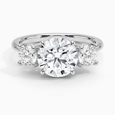 a three stone engagement ring with diamonds on the sides