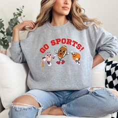 This Go Sports! sweatshirt is the perfect addition for the sports fan in your life. The retro graphic is sure to be a conversation starter and will put a smile on everyone's face. Whether you're lounging at home or catching the game, this sweatshirt is the perfect blend of comfort and style. Get yours today and add a touch of fun to your wardrobe! Gildan 18000 Crewneck unisex sweatshirt True to size, size up for oversized fit. Please check the size chart in photos. 50% cotton, 50% polyester Mach Athletic Heather Tops For Sports Fans, Game Day Athletic Heather Crew Neck Sweatshirt, Sports Season Sweatshirt With Team Logo, Sports Season Fan Gear Sweatshirt, Sports Fan Gear Sweatshirt For Sports Season, Team Logo Sweatshirt For Sports Season, Athletic Heather Sweatshirt For Sports Fans, Athletic Heather Sportswear Sweatshirt For Sports Season, Fan Gear Sweatshirt For Sports Season