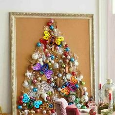 a christmas tree made out of ornaments on a table next to a framed photo and other decorations