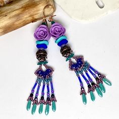 "Fringe Earrings, RHAPSODY in BLUE, Flower Earrings, TwinklingOfAnEye, Long Earrings, Purple Earrings, Bohemian Earrings, Beaded Fringe, OOAK #847 RHAPSODY in BLUE There's nothing like living \"on the fringe\" (lol), and these beautiful earrings are certainly a good choice to do it in! They feature beautifully bohemian Artisan beaded fringe charms in cool colors, paired with lovely Artisan clay roses. I've added stacks of stunning copper caps, and wavy neon Czech glass spacers. Teeny, tiny Czech Bohemian Blue Flower Earrings With Dangling Beads, Bohemian Blue Flower Earrings, Blue Beaded Bohemian Flower Earrings, Blue Bohemian Flower Earrings With Colorful Beads, Bohemian Blue Flower Earrings With Colorful Beads, Clay Roses, Blue Flower Earrings, Rhapsody In Blue, Bunny Earrings