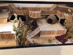 a model of a building with plants and rocks