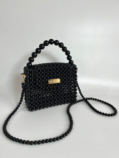 Bead bags are 100% handmade. Bead strap length can be changed upon request. It fits phone, card holder, lipstick, earphone case. It will come with a special pouch. The beads are navy in color. It is made with white or black pearls upon request. * Dimensions - Width: 20 cm - Height: 16 cm ( 26 cm with handle) - Depth: 8 cm - Strap Length: 108 cm * Materials - Luxury Plated Pearl - Gold Material * Shipping - Ships worldwide from İstanbul, Turkey. - Production time before shipment is 2-7 working da Black Handheld Portable Evening Bag, Black Portable Handheld Evening Bag, Portable Rectangular Phone Bag, Black Shoulder Bag Phone Bag As Gift, Black Shoulder Phone Bag As Gift, Black Shoulder Phone Bag For Gift, Elegant Black Phone Bag Gift, Black Handheld Beaded Shoulder Bag, Black Rectangular Bag With Pearl Handle