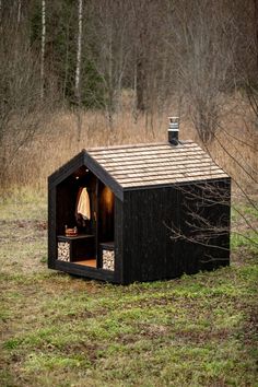 an outhouse in the middle of a field with a towel hanging from it's roof