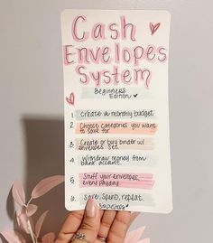 a hand holding up a sign that says cash envelopes system and the words below it