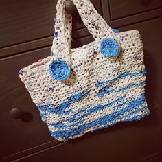 a crocheted bag sitting on top of a wooden table next to a drawer