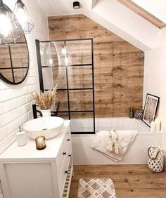 a white bathroom with wooden walls and flooring is pictured in this image, it appears to be an attic - like space