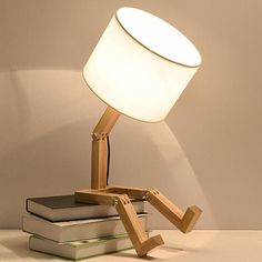 a wooden table lamp sitting on top of two books next to a white light bulb