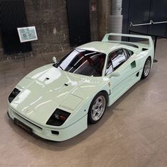 a mint green sports car parked in a garage