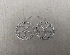 "These are so unique and cool! Big silver flower hoop earrings. They are modern and whimsical. Eye catching and versatile. Dress them up or down. The earrings measure 1 3/8\" long by 1 3/8\" wide and are made from plated silver. They hang from simple silver ear wire hooks. Overall drop length is 1 1/2\". I have a matching necklace in my shop if you would like the whole set. Here is a direct link Thanks for stopping by! Please take a moment and visit the rest of my Etsy store. I have many more un Spring Dangle Hoop Earrings For Pierced Ears, Metal Flower-shaped Earrings For Spring, Spring Dangle Hoop Earrings, Flower-shaped Metal Earrings For Spring, Whimsical Spring Flower Earrings With Ear Wire, Spring Flower-shaped Metal Earrings, Silver Flower Metal Earrings For Spring, Spring Small Hoop Earrings For Pierced Ears, Spring Flower Hoop Earrings For Pierced Ears