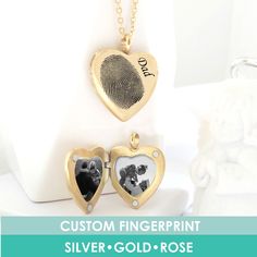 two heart shaped lockes with a fingerprint on the front, and a gold - plated heart in the middle