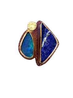 Gold, Silver & Stone Ring - The mysteries of different blues are in this one of a kind ring.  The materials are opal doublet, natural surface lapis with hints of pyrite, sterling silver, 18k bi-metal, and fine silver bezels.  The process are the metals are sawn and bezels made then soldered onto the sterling silver base.  Base is textured,  ring shank is soldered on and stones are set.  Lastly the ring is polished and oxidized.  Please note, the fine silver bezels can take on a golden glow f Unique Blue Multi-stone Opal Ring, Unique Blue Opal Ring, Silver Stone Ring, Ring Shank, Golden Glow, Textured Ring, Boulder Opal, Stone Ring, Fine Silver