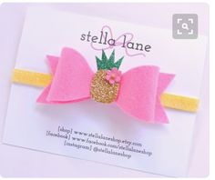 a pink and gold bow with a pineapple on the top is attached to a card