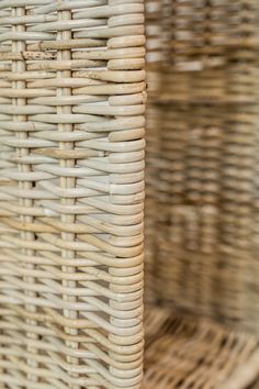 two wicker baskets are stacked on top of each other, one is white and the other is brown