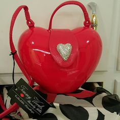 a red heart shaped purse sitting on top of a table