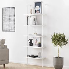 a living room with a couch, chair and book shelf on the wall next to a potted plant