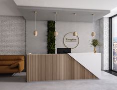 the reception area is decorated with greenery and hanging lights, along with modern furniture