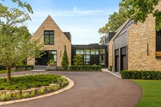 a large house with a driveway in front of it and lots of windows on the side