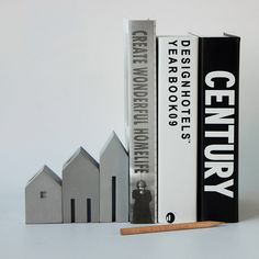 three books are stacked on top of each other in front of a row of houses