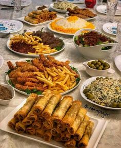 a table topped with lots of different types of food and dishes filled with sauces