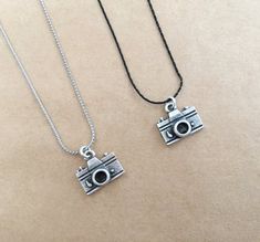 This listing is for one Unisex Silver Plated Camera Charm Necklace.  It is a wonderful gift for a photographer or someone who has a passion for cameras or photography. This cute camera necklace is available in two colours: either black or silver.  You can also choose your desired length: 40, 45, 50 cm or adjustable length. The necklace will arrive to you nicely gifted. If you are interested in registered shipping, you can choose the available option during checkout. For other Unisex Necklaces pl Camera Charm Bracelet, Photography Sayings, Pendant Photography, Charm Photography, Camera Charm, Camera Necklace, Men's Necklaces, Cute Camera, Plate Camera