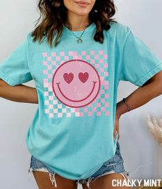 a woman wearing a t - shirt with a smiley face on it