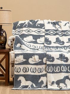 a blue and white blanket sitting on top of a wooden table next to a lamp