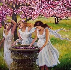 three girls in white dresses are washing their hands at a fountain with flowers on it